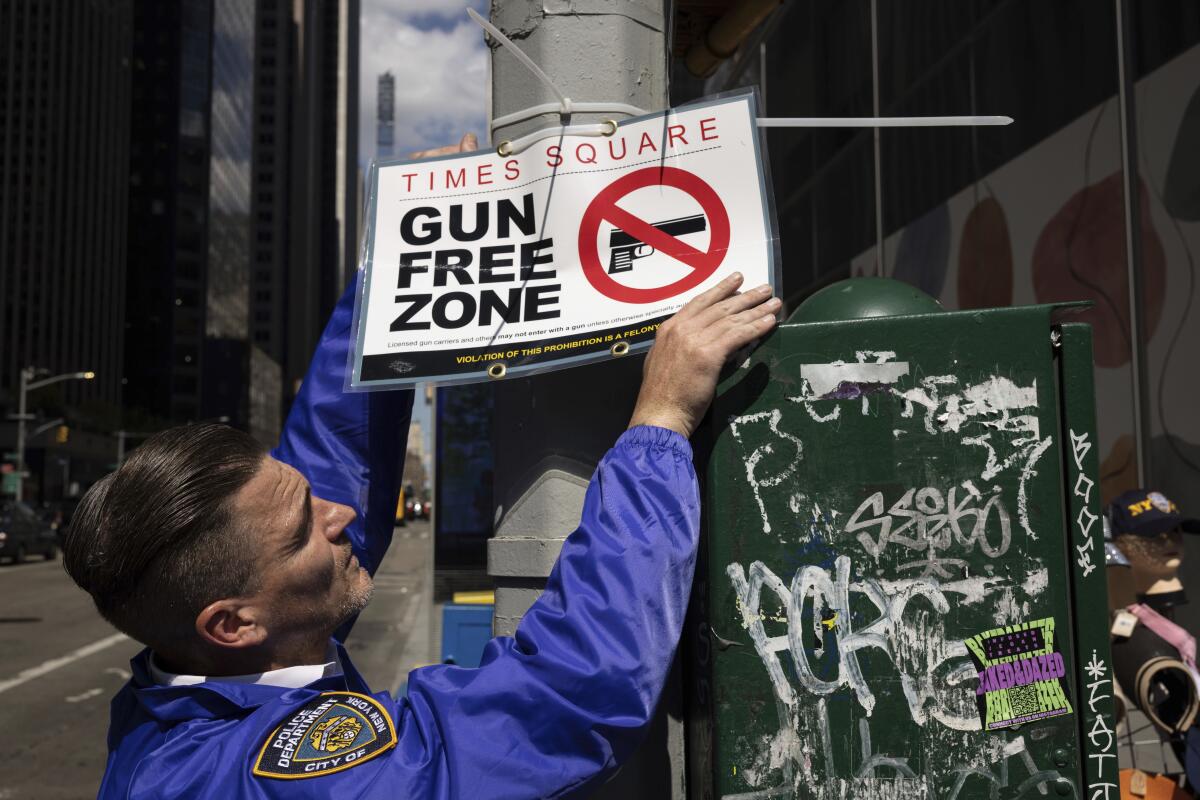 New York police official posting sign announcing a gun-free zone