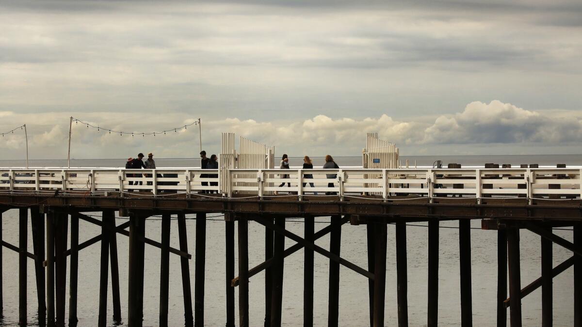 Pedestrians enjoy the Malibu Pier last week. Southern California will remain gray into the weekend as a storm moves through the area.