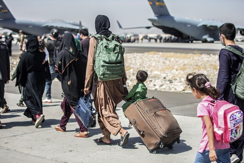 In this image provided by the U.S. Marine Corps, families walk towards their flight during ongoing evacuations at Hamid Karzai International Airport, Kabul, Afghanistan, Tuesday, Aug. 24, 2021. (Sgt. Samuel Ruiz/U.S. Marine Corps via AP)