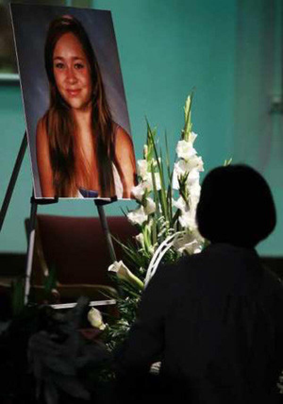 A mourner pauses in front of a picture of Ashton Sweet during a memorial service at the Chinese Baptist Church of Central Orange County in Irvine.