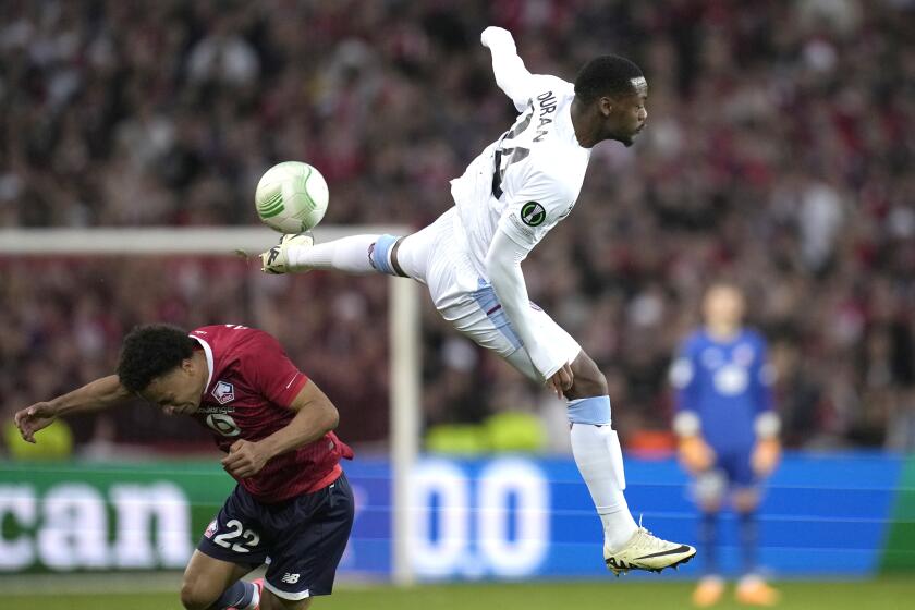 Aston Villa's Jhon Duran, right, and Lille's Tiago Santos fight for the ball during the Europa Conference League quarter final second leg soccer match between Lille and Aston Villa at the Pierre Mauroy stadium in Villeneuve d'Ascq, northern France, Thursday, April 18, 2024. (AP Photo/Christophe Ena)