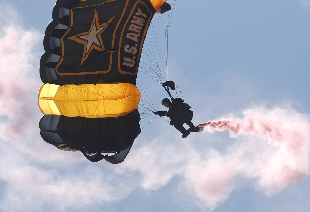 A member of the U.S. Army parachute team drops into the welcoming ceremony.