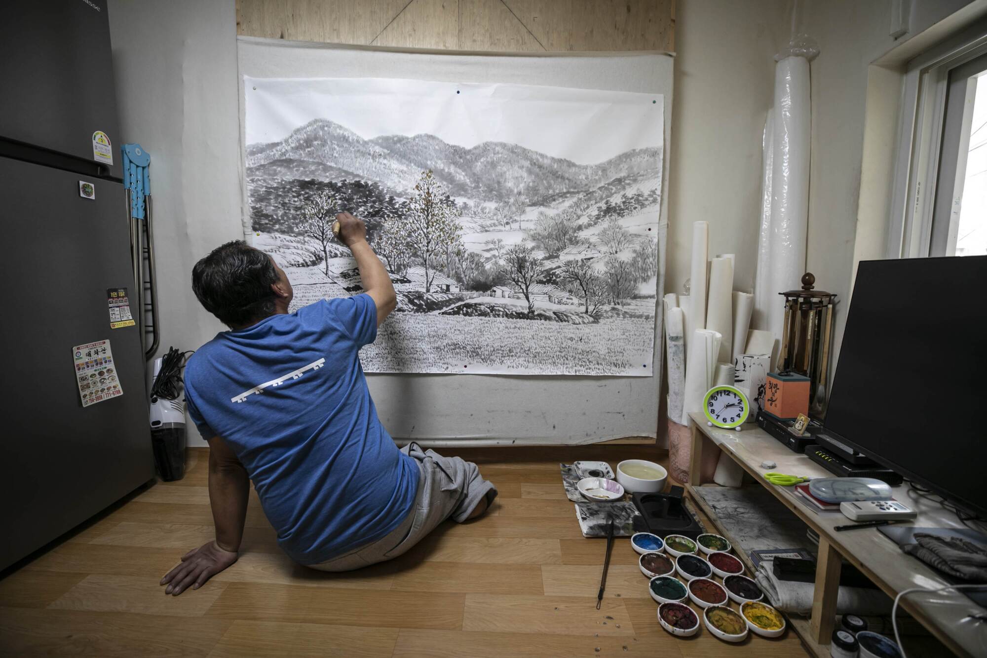 Mr. Yoon Yong-ju, representative of the neighborhood community center in Jjokbangchon in Dongja-dong, paints his artwork