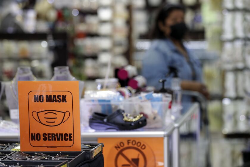 Los Angeles, CA - July 14: Sustained jumps in cases and hospitalizations fueled by the hyper-infectious BA.5 subvariant pushed Los Angeles County into the high COVID-19 community level Thursday, a shift that could trigger a new public indoor mask mandate by the end of this month unless conditions improve. A store that requires shoppers to wear masks, at Santee Alley on Thursday, July 14, 2022 in Los Angeles, CA. (Irfan Khan / Los Angeles Times)