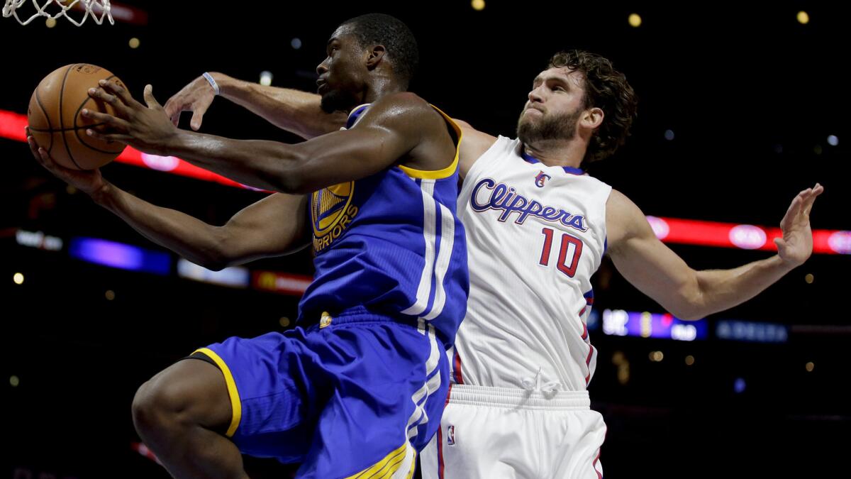 Golden State Warriors forward Harrison Barnes, left, drives to the basket past Clippers forward Spencer Hawes during a preseason game Tuesday.