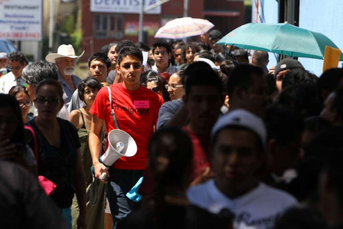 UCLA student Justino Mora, in red shirt, walks with hundreds of young immigrants lining up for President Obama's Deferred Action for Childhood Arrivals program in 2012. The program protects some young people who are in the country illegally from deportation.