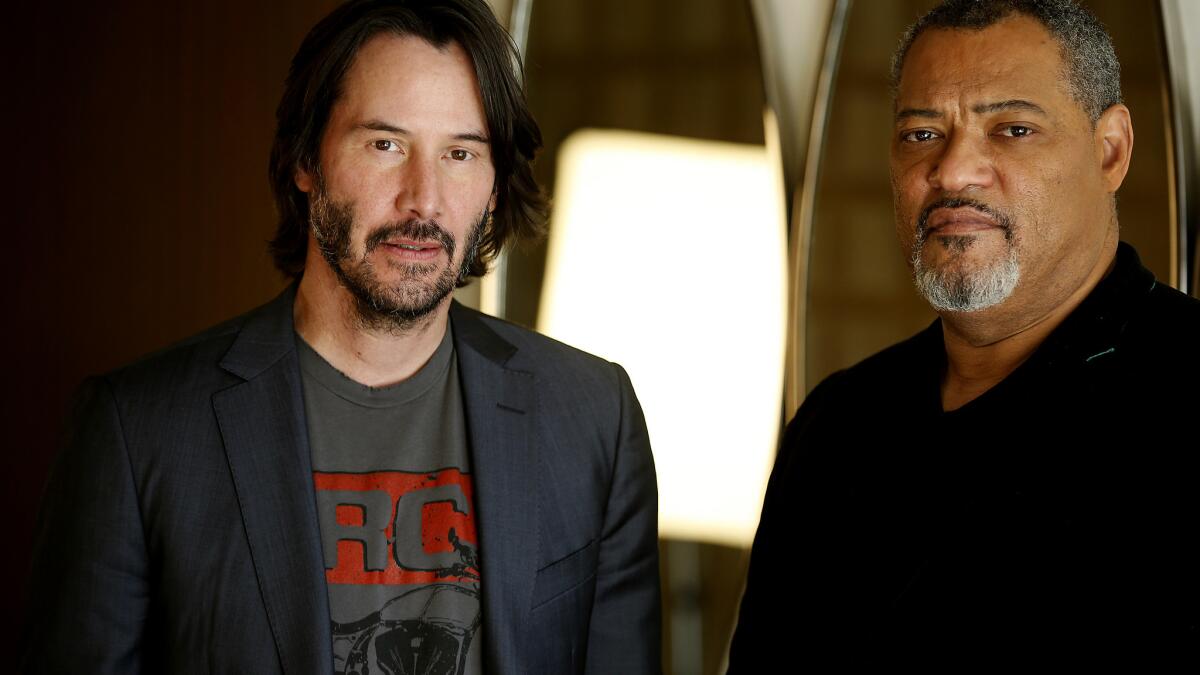 Laurence Fishburne, left, and Keanu Reeves, cast members in John Wick:  Chapter 2, pose together at the premiere of the film at ArcLight Cinemas  on Monday, Jan. 30, 2017, in Los Angeles. (