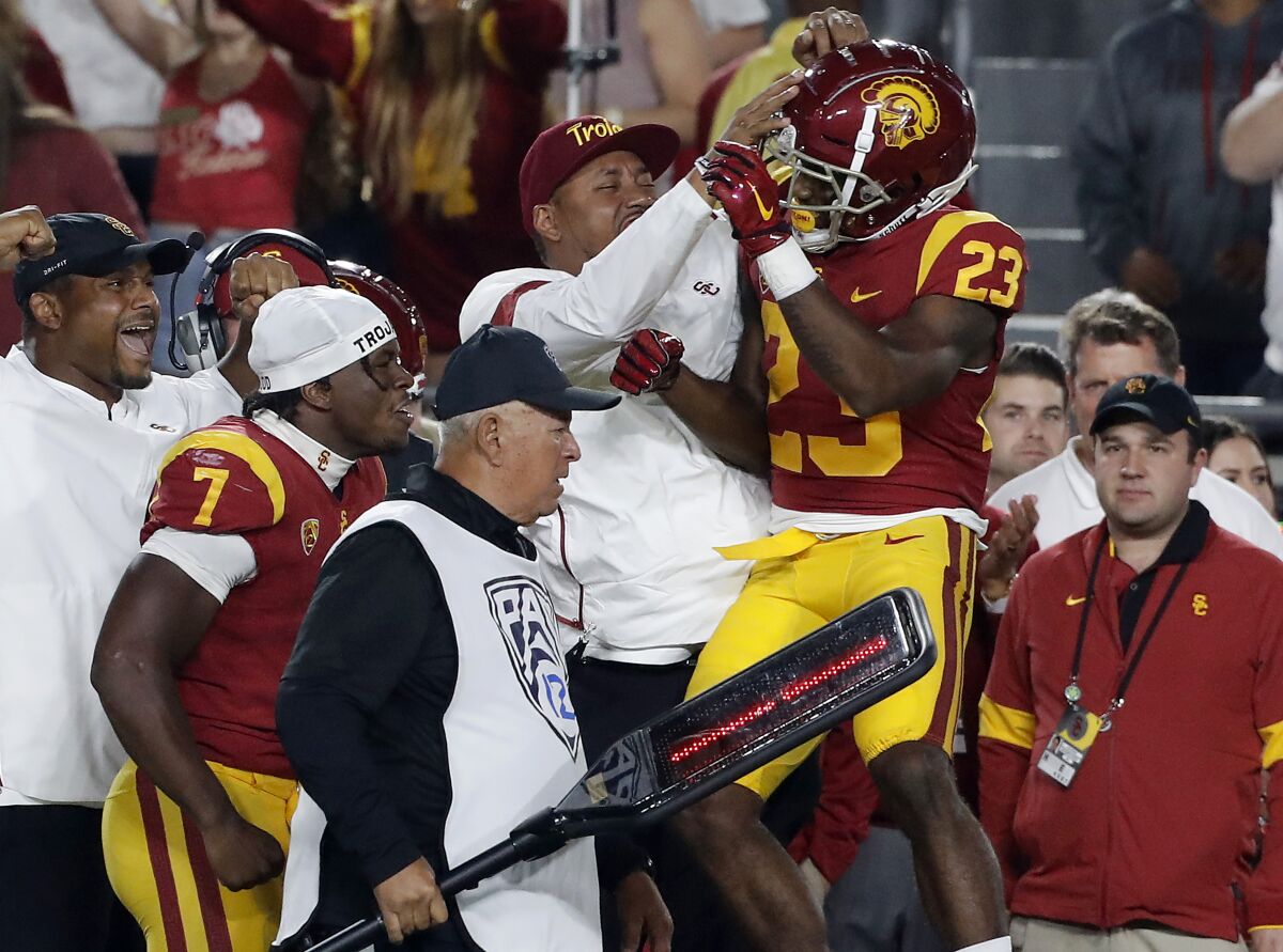 USC running back Kenan Christon (23) celebrates on the sideline after scoring a touchdown against Arizona in the fourth quarter Saturday night at the Coliseum.
