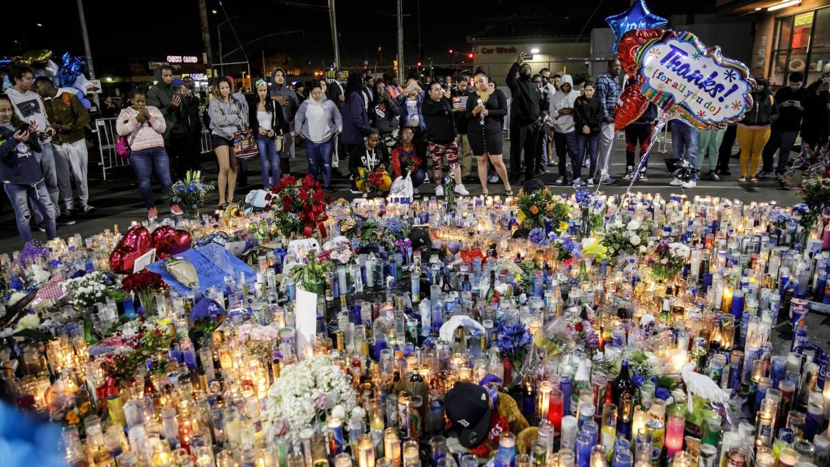 Community members remember slain rapper Nipsey Hussle at a makeshift memorial outside his South L.A. clothing store on Tuesday.