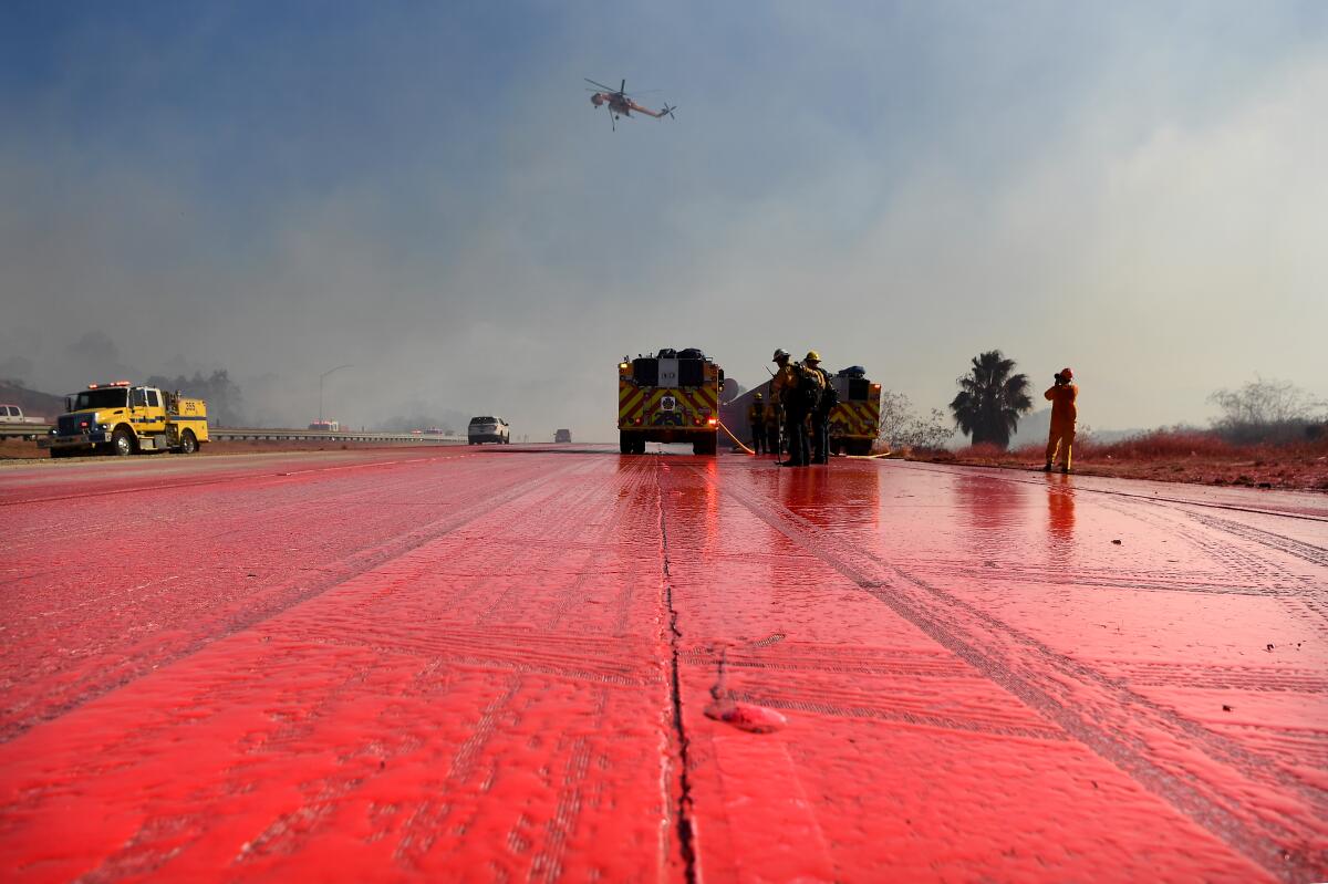 Phos-Chek covers the southbound 23 Freeway as firefighters make a stand against the 2019 Easy fire burning in Moorpark.