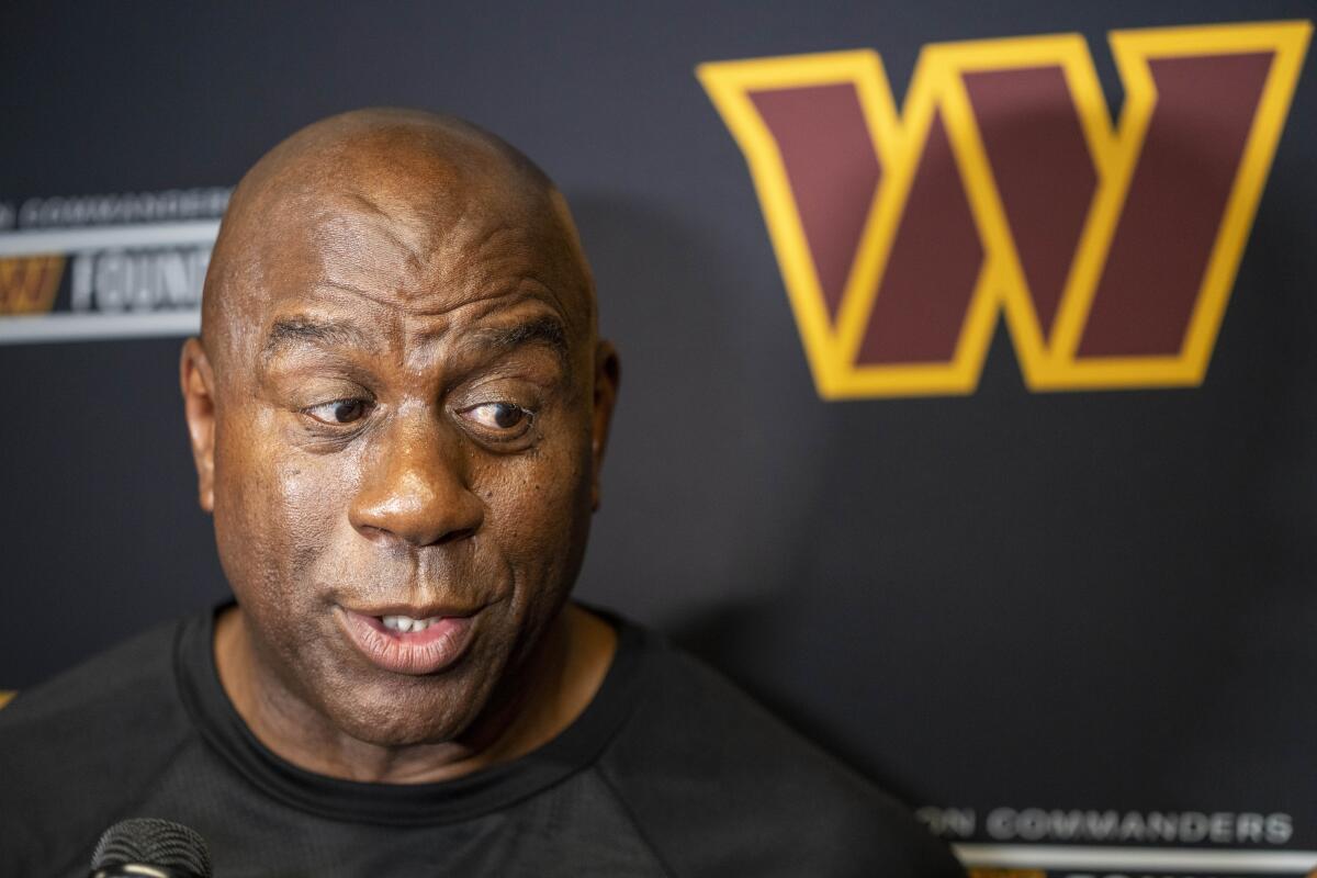 Washington Commanders part-owner Magic Johnson speaks with reporters 