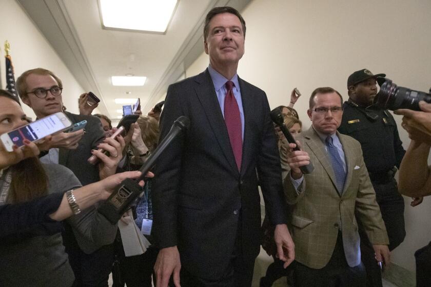 Former FBI Director James Comey, with his attorney, David Kelley, right, speaks to reporters after a day of testimony before the House Judiciary and Oversight committees, on Capitol Hill in Washington, Friday, Dec. 7, 2018. (AP Photo/J. Scott Applewhite)