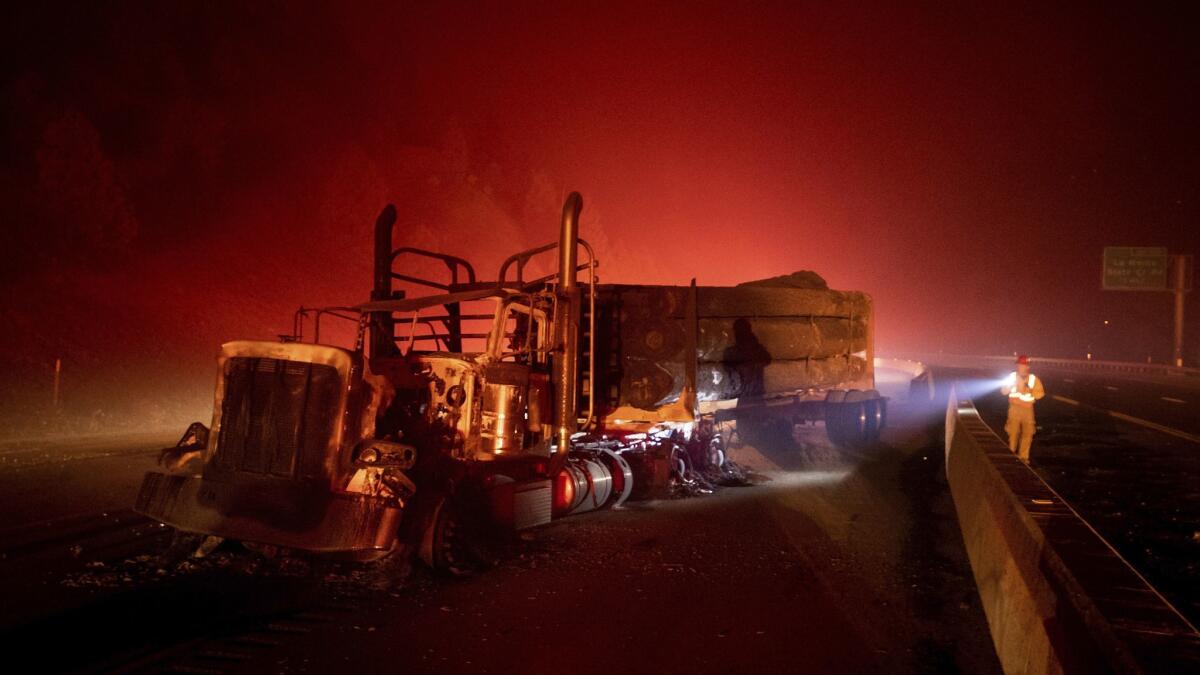 A scorched logging truck rests on the 5 Freeway as the Delta fire burns in the Shasta-Trinity National Forest.