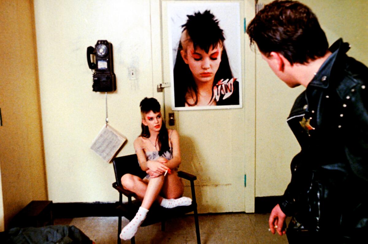 A mohawked punk girl and a rocker chat backstage.