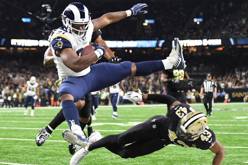 NEW ORLEANS, LOUISIANA, NOVEMBER 4, 2018-Rams running back Malcolm Brown leaps over Saints safety Marcus Williams to score a touchdown in the 3rd quarter at the Mercedes Benz Superdome in Louisiana Sunday. (Wally Skalij/Los Angeles Times)