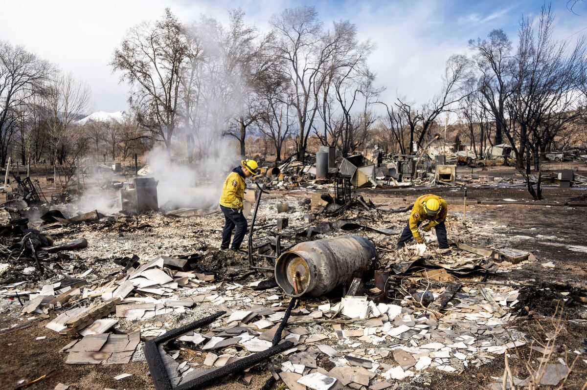 Firefighters sift through debris after the Mountain View fire tore through the town of Walker in Mono County.