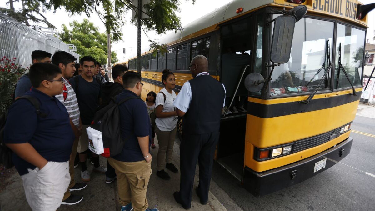 Students line up at a district bus stop next to Jefferson High School in Los Angeles on August 18, 2015.