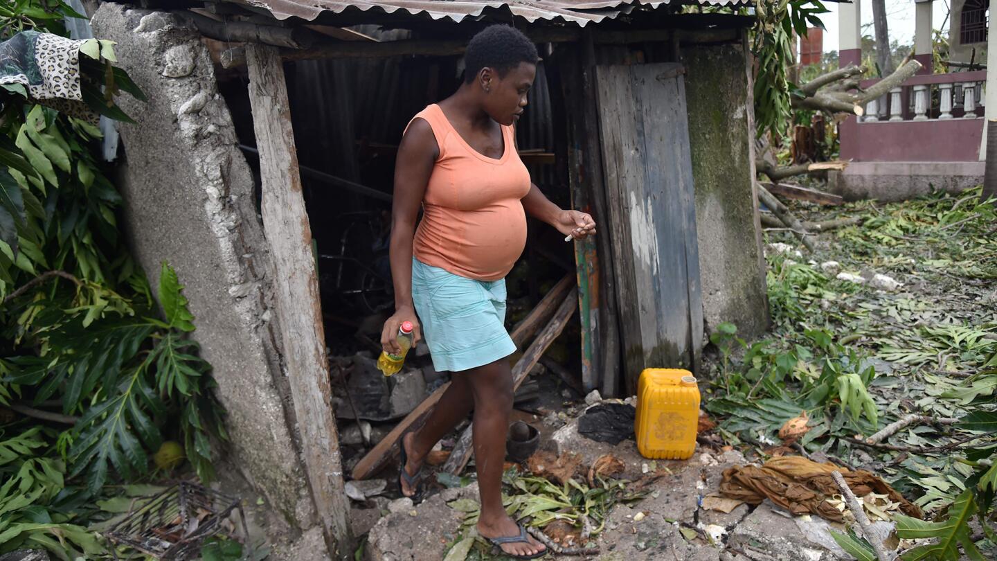 Stephanie, age 26 walks outside of her house that was destroyed after Hurricane Matthew, in Croix Marche-a-Terre, in Southwest Haiti, on October 6, 2016.