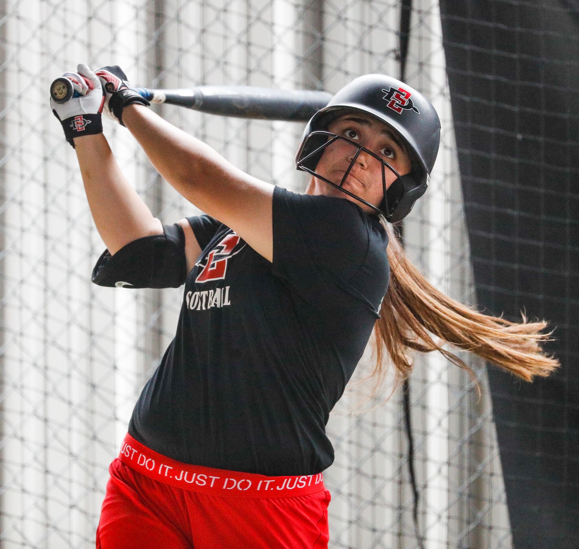 San Diego State infielder Jillian Celis takes a swing in the batting cage during Tuesday's practice.