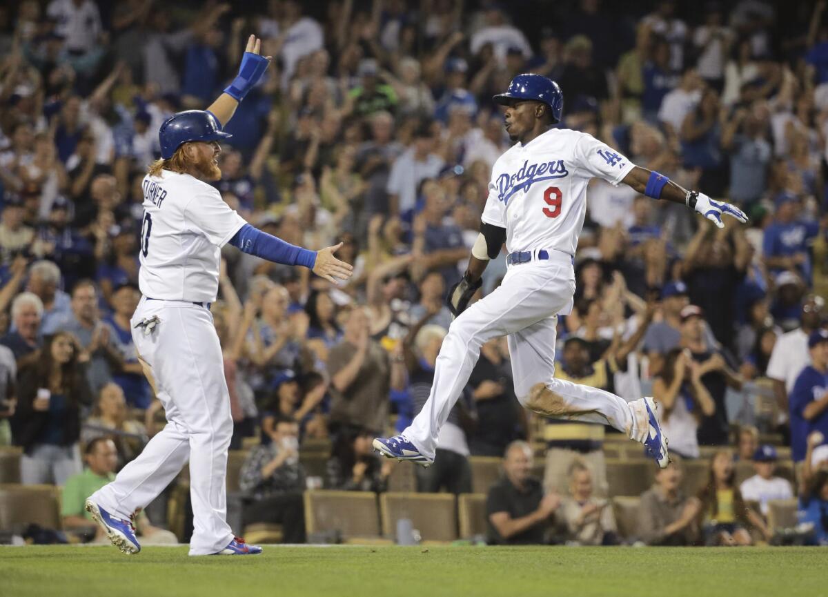 Dee Gordon, right, celebrates with Justin Turner after they scored on a hit by Hanley Ramirez during the eighth inning Saturday against Arizona.
