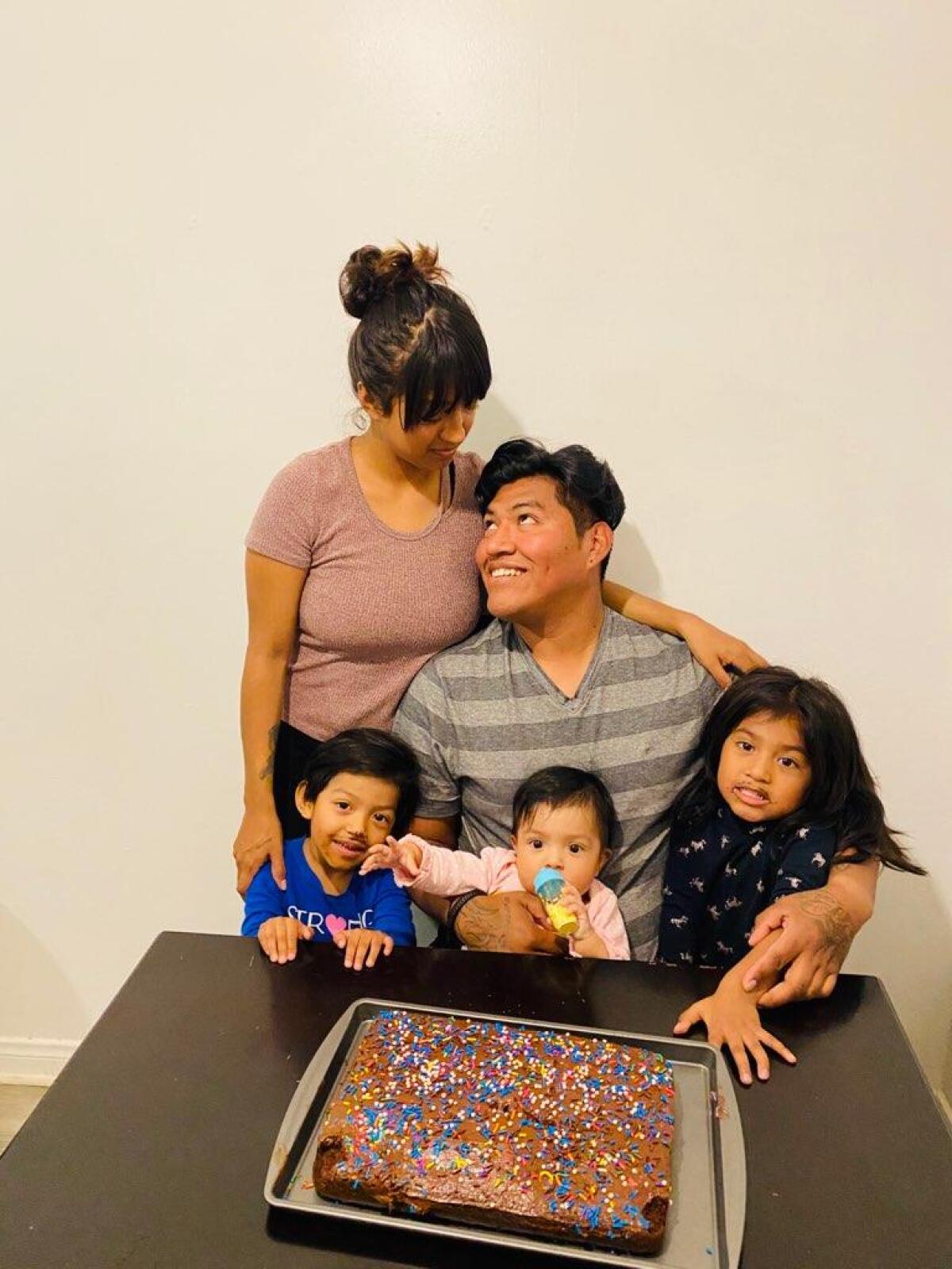 Gabriela Andrade, left, looks down at her husband, Henry Saldana Meija, right.