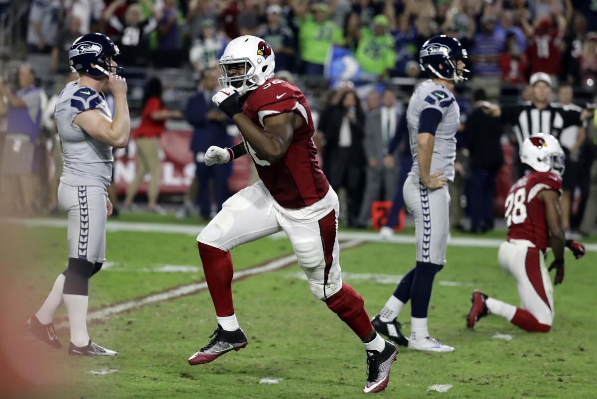 Cardinals linebacker Kareem Martin, center, reacts to Seattle Seahawks kicker Stephen Hauschka's, left, missed game-winning field goal attempt in the final seconds of overtime.
