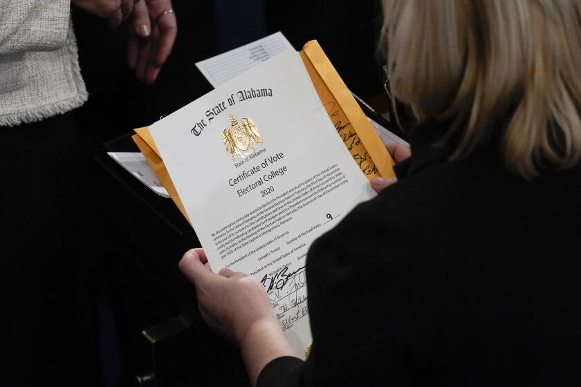 The certification of Electoral College votes for the state of Alabama is unsealed during a joint session of the House and Senate convenes to confirm the electoral votes cast in November's election, at the Capitol, Wednesday, Jan 6, 2021. (AP Photo/Andrew Harnik)
