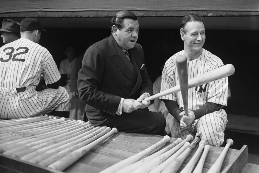 These two famous baseball players are shown in the Yankee dugout before the beginning of the Second World Series Game between the Yankees and Cincinnate Reds on Oct 5, 1939 in New York. Babe Ruth, the old swatsmen, fondles a bat in a seemingly "Rarin' to go" way while first baseman Lou Gehrig, out of action since early in the season, laughs at the whole thing. (AP Photo)