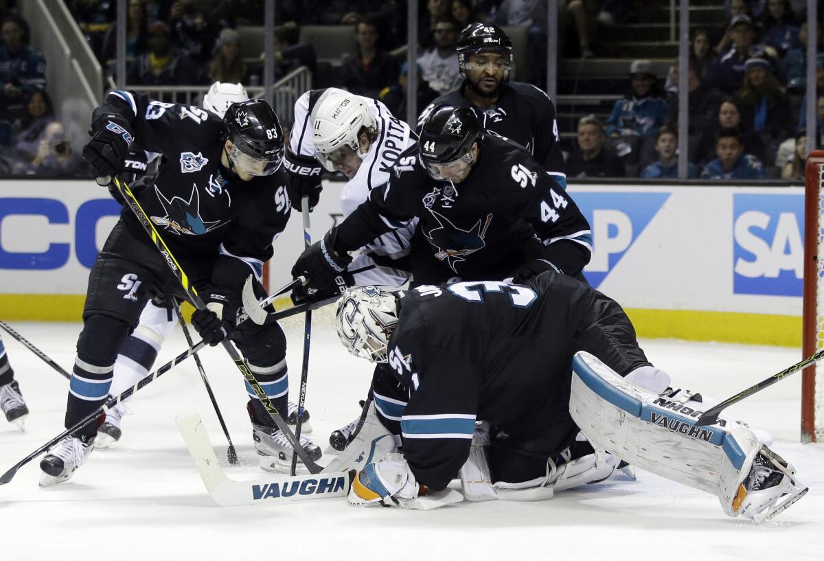 Sharks goalie Martin Jones, bottom, stops a shot as Kings forward Anze Kopitar, middle, closes in during the second period.