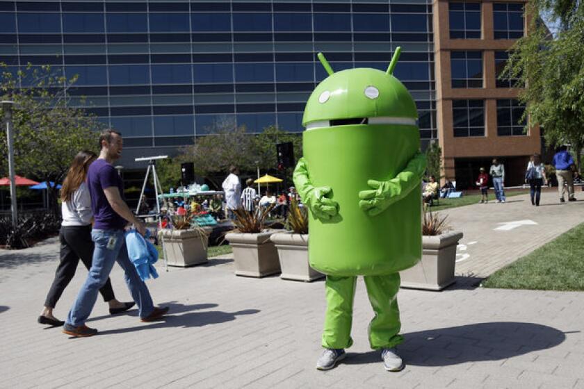 A person costumed as the Android operating system mascot stands at the Google headquarters in Mountain View, Calif.