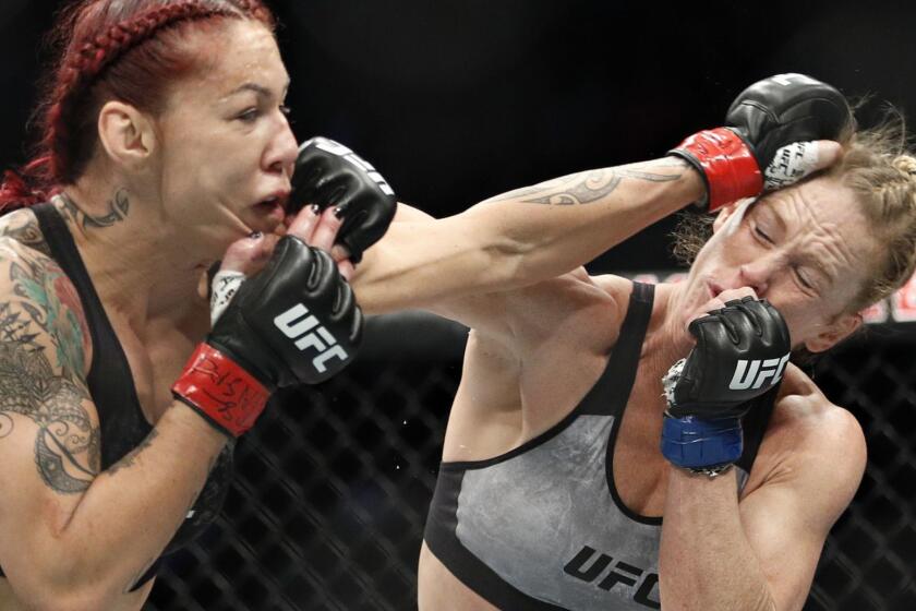 Holly Holm, right, and Cris Cyborg exchange blows during a featherweight championship mixed martial arts bout at UFC 219, Saturday, Dec. 30, 2017, in Las Vegas. (AP Photo/John Locher)