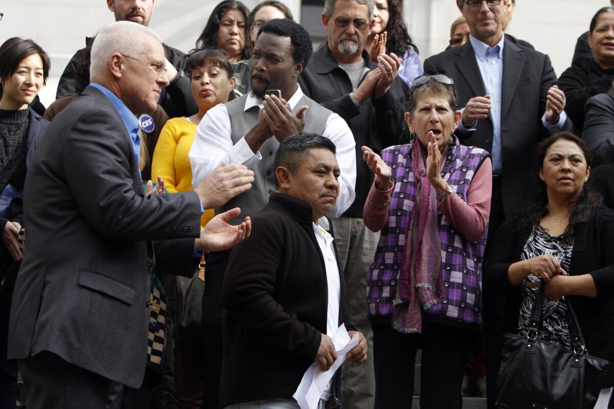 Los Angeles City Councilman Mike Bonin, left, and worker Inez Luna, 54, right, during a news conference on the steps of City Hall.