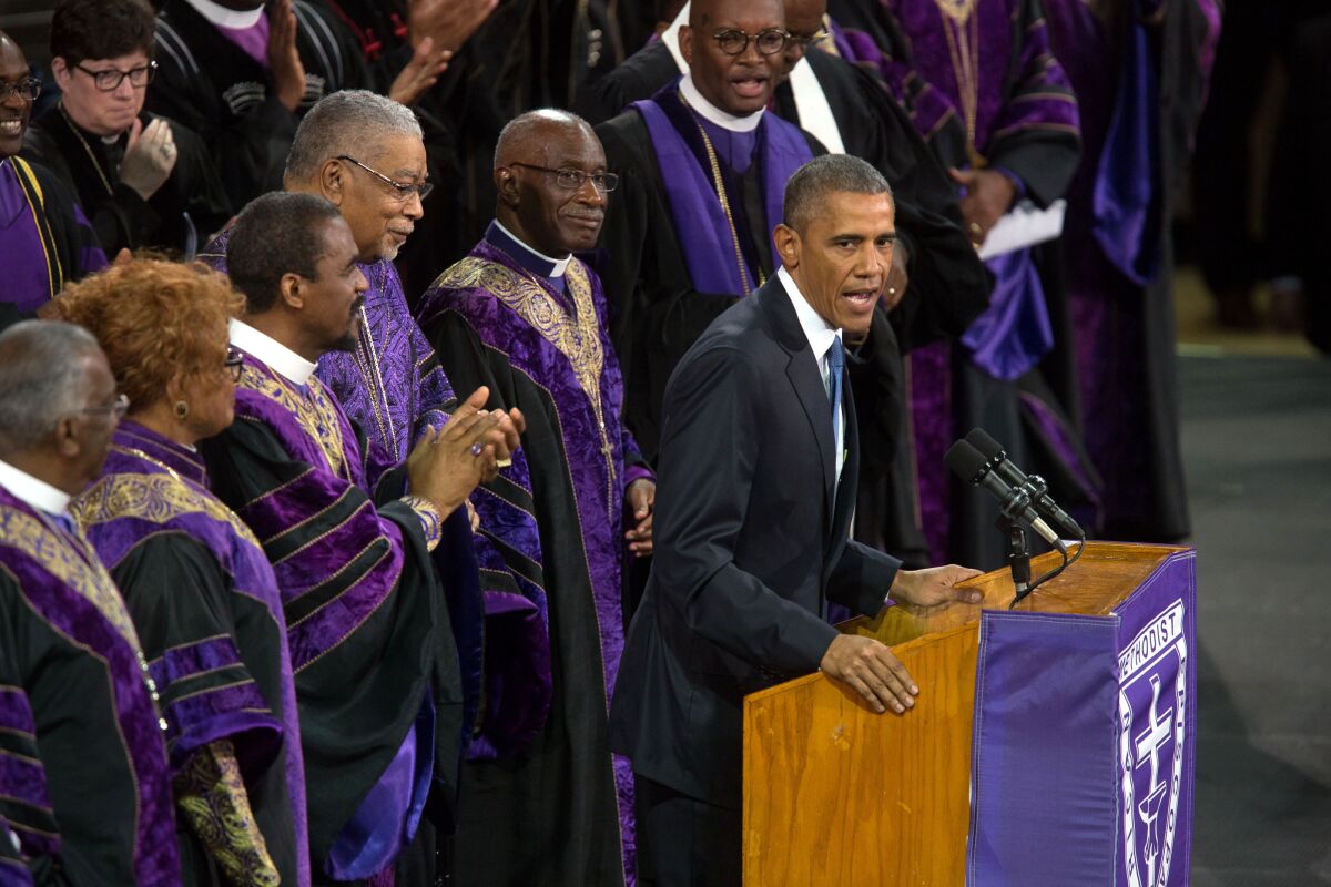 President Obama speaks at a lectern, backed by members of a church choir
