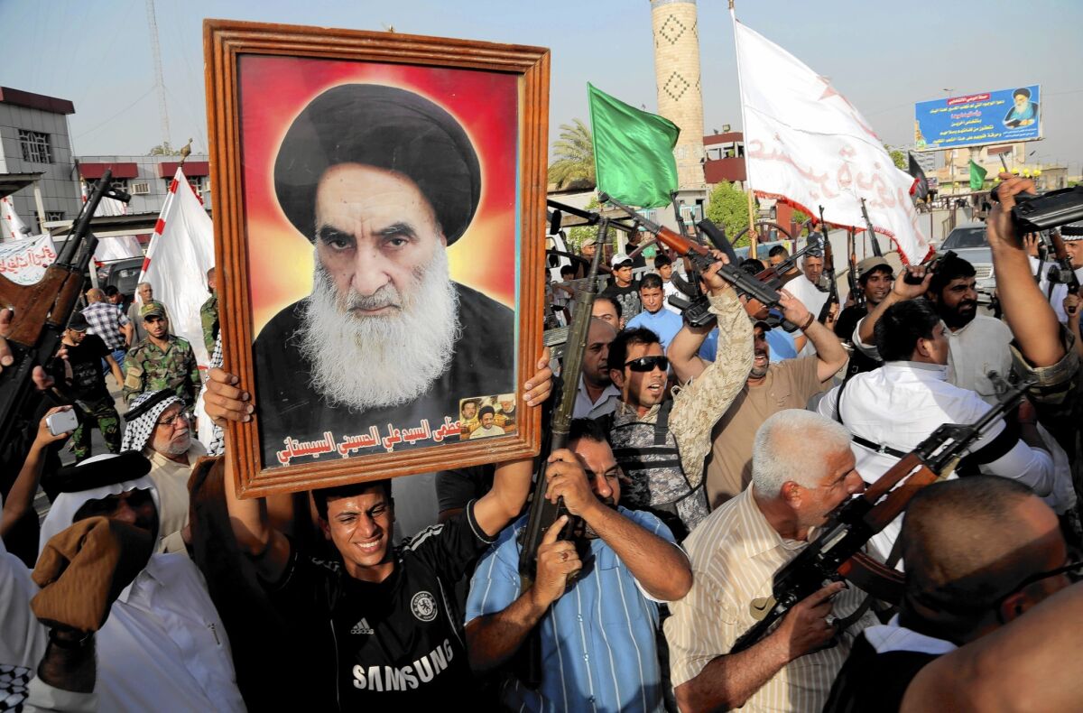 Iraqi Shiite tribal fighters chant and hold a poster of Grand Ayatollah Ali Sistani. On Friday, Sistani called on Iraqi leaders to form a new government with broad national acceptance.