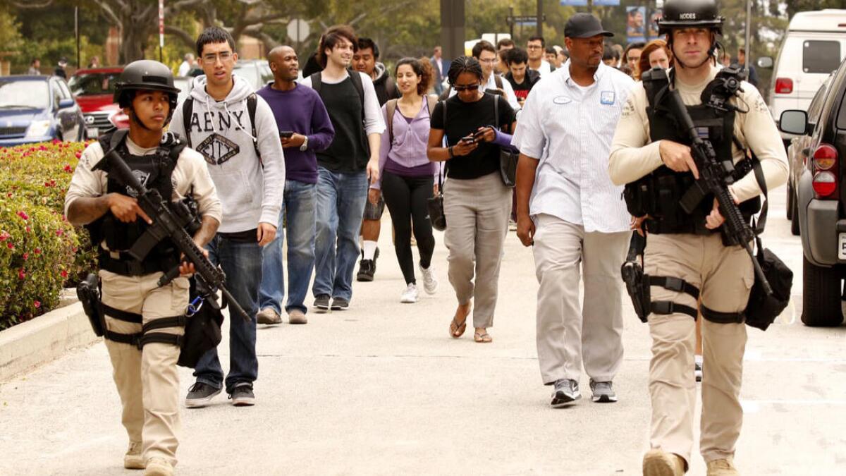 Police escort people at UCLA after a lockdown was lifted following a shooting on campus.