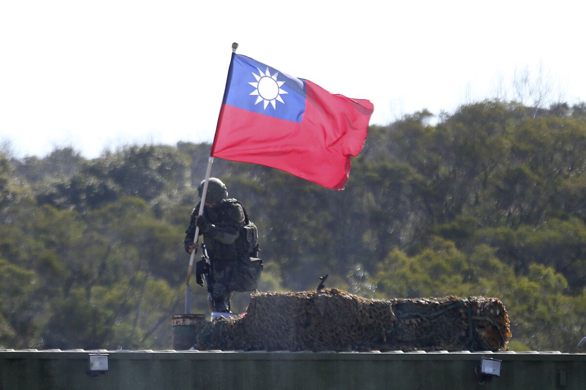 FILE - In this Jan. 19, 2021, file photo, a soldier holds a Taiwanese flag during a military exercise aimed at repelling an attack from China in Hsinchu County, northern Taiwan. Japan believes rising tension surrounding Taiwan requires its attention “with a sense of crisis” as China intensifies military activities in the area and the United States steps up support for the self-governing island. (AP Photo/Chiang Ying-ying, File)