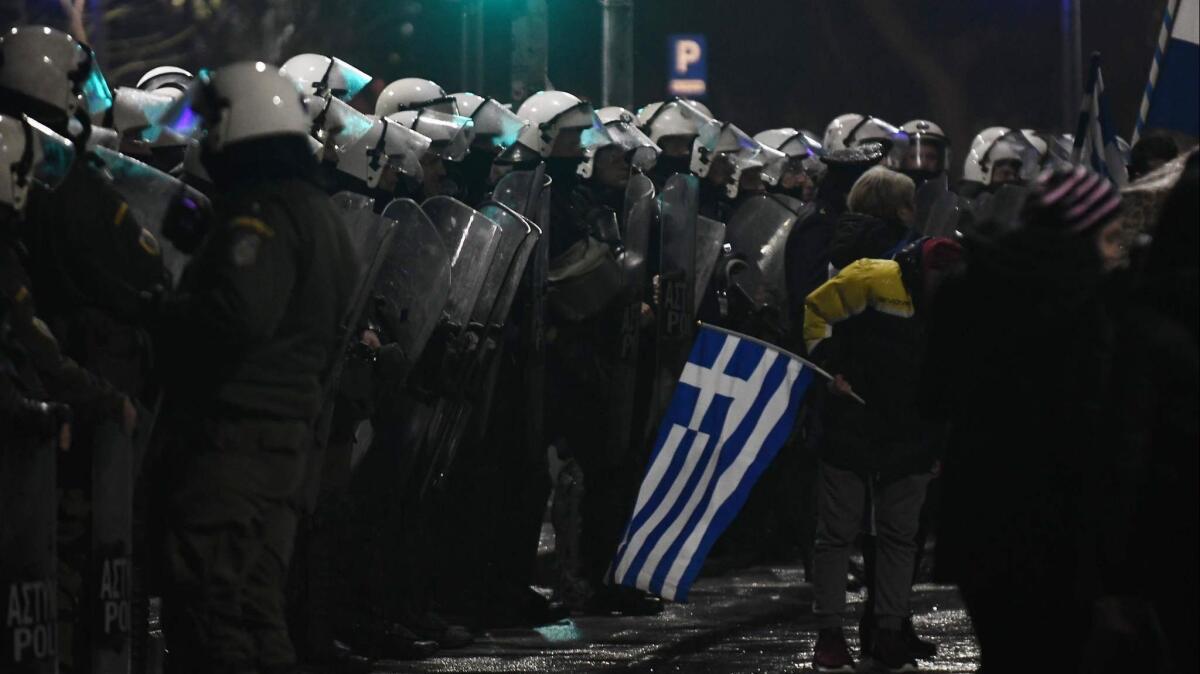 Demonstrators face Greek riot police as they protest on Dec. 14, 2018, in Thessaloniki to protest the country's name deal with Macedonia.