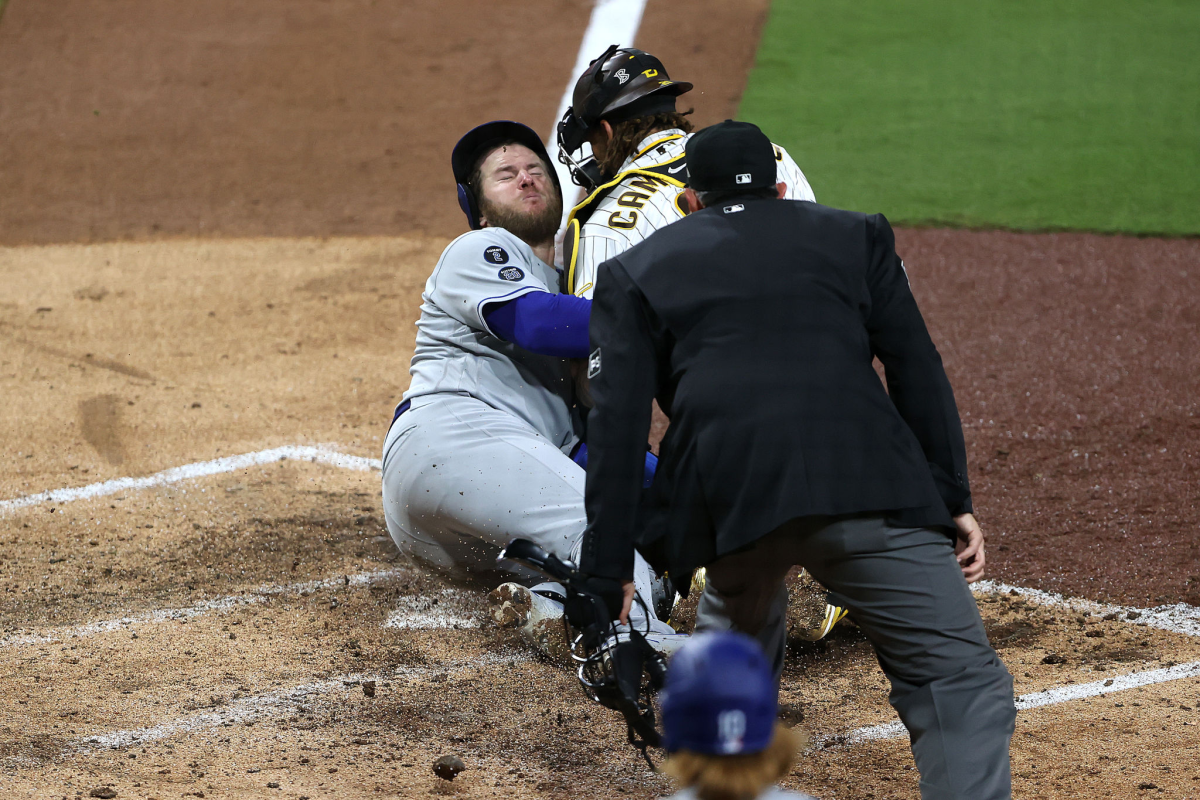 Dodgers baserunner Max Muncy is safe at home plate after beating the tag from Padres catcher Luis Campusano.