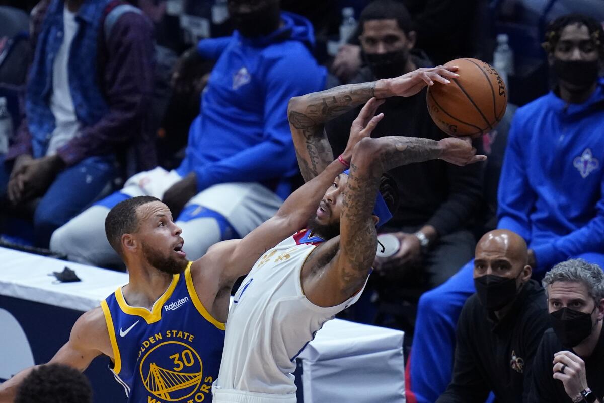 New Orleans Pelicans forward Brandon Ingram tries to control the ball under pressure from Golden State Warriors guard Stephen Curry (30) in the first half of an NBA basketball game in New Orleans, Tuesday, May 4, 2021. (AP Photo/Gerald Herbert)