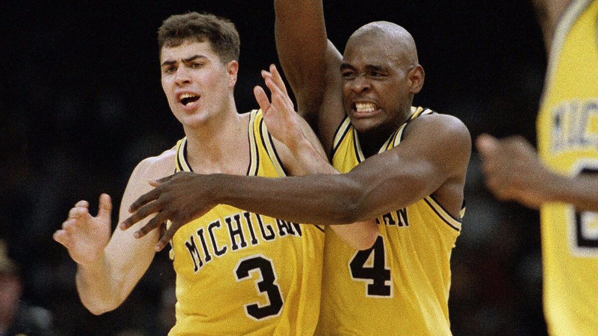 Michigan's Chris Webber (4) and Rob Pelinka (3) celebrate after beating Kentucky, 81-78, in overtime to advance to the 1993 NCAA Tournament final on April 3, 1993.