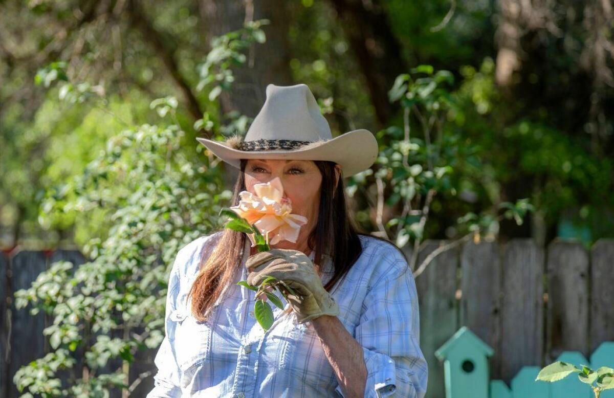 Huston smells a rose clipped from her garden. “My friends laugh at me for trying to create an English garden at 4,000 feet in the Rockies, and I quite agree,” says the actress. “It’s completely insane because all I do is replant roses.”