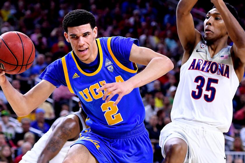 UCLA guard Lonzo Ball is fouled by Arizona guard Kadeem Allen (partially obscured) while he drives against Wildcats guard Allonzo Trier.