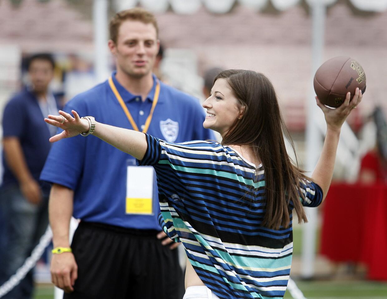 With her NFL quarterback boyfriend Greg McElroy watching, Meredith Gray, of Decatur, AL, winds up to throw the football into a target at the Rose Bowl in Pasadena for the NFL All-Access Event.