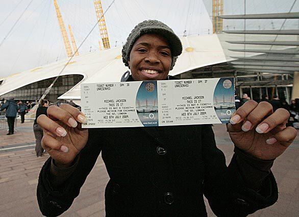Michael Jackson fan Ayesha Obi, 19, poses with the first ticket bought at the O2 Arena in London for one of Michael Jackson's summer 2009 concerts. Hundreds camped out overnight to get their hands on tickets for the Jackson's comeback concerts in London after extra shows were announced to cope with demand.
