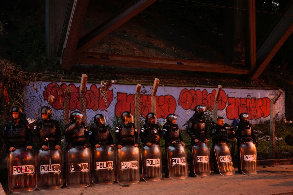 La policía antimotines monta guardia tras un enfrentamiento entre seguidores del local Municipal de Guatemala y el Olimpia de Honduras, el jueves 18 de agosto de 2022 (AP Foto/Moisés Castillo)