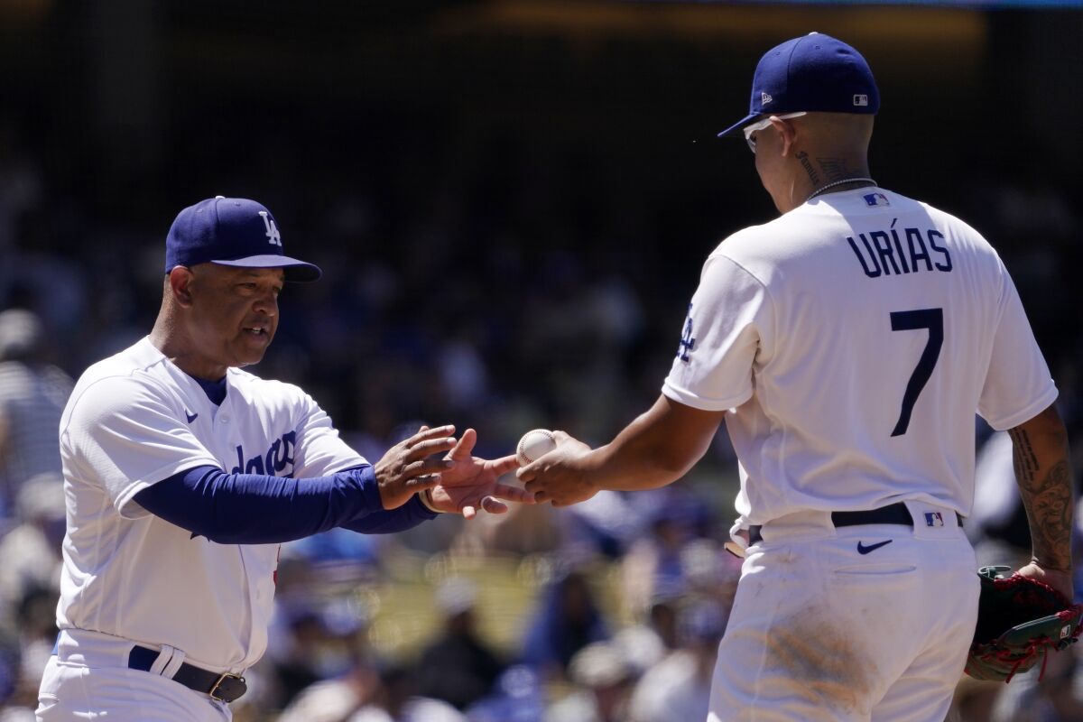 Dodgers manager Dave Roberts, left, takes starting pitcher Julio Urías out of the game.