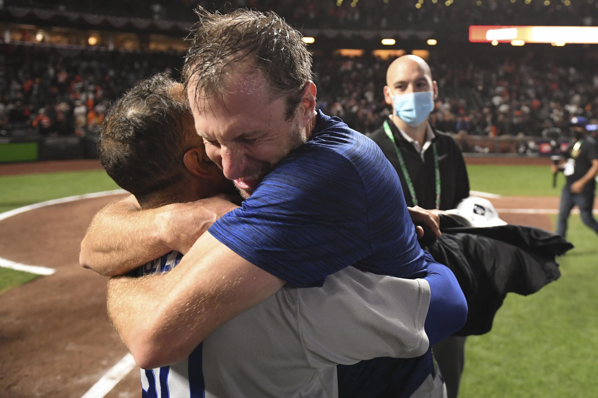 Los Angeles Dodgers' Max Scherzer, right, hugs manager Dave Roberts after game five.