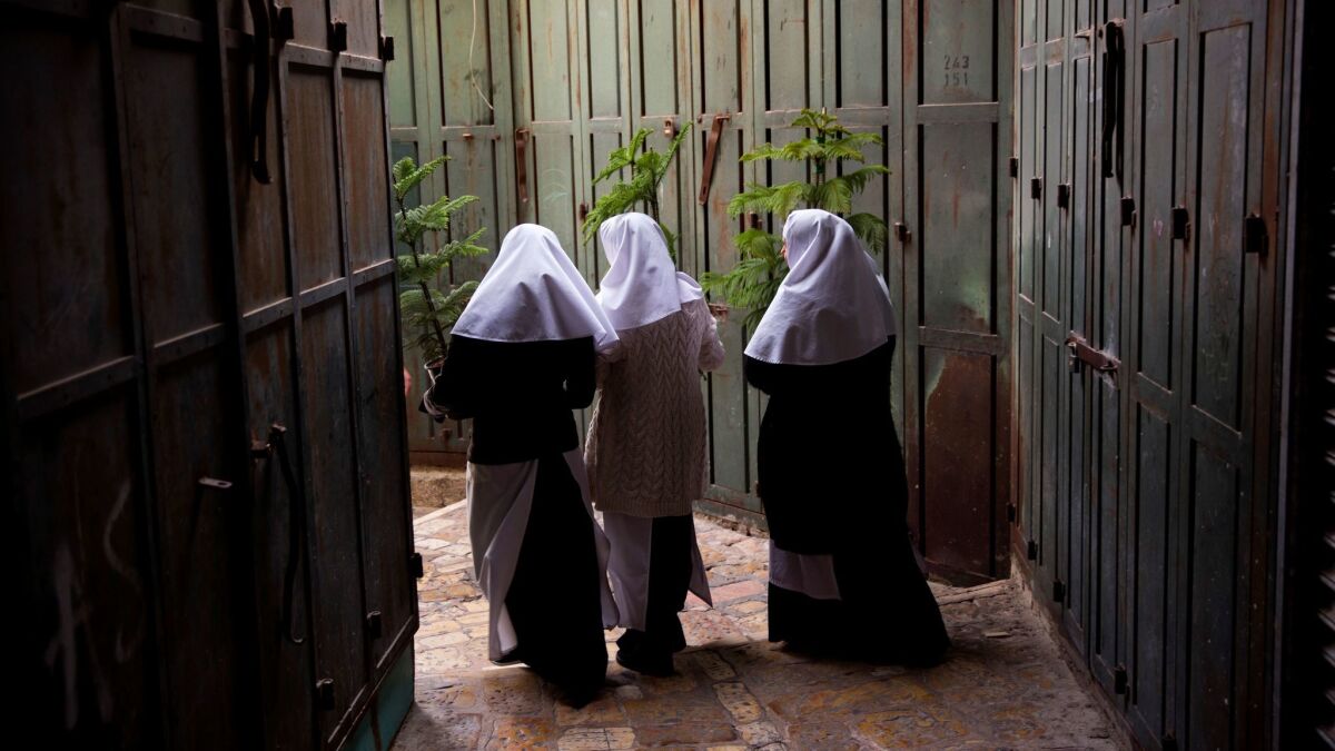 Christian nuns carry Christmas trees in Jerusalem's Old City on Dec. 21.