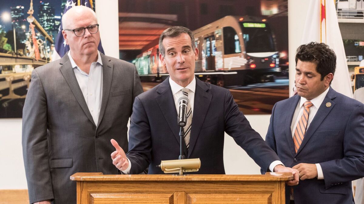 Los Angeles Mayor Eric Garcetti criticizes the GOP tax bill, flanked by Rep. Jimmy Gomez, right, and House Democratic Caucus Chairman Joe Crowley, left, during news conference at Metro headquarters.