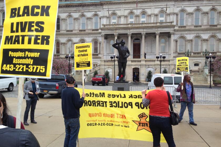 Demonstrators protest the death of Freddie Gray outside Baltimore City Hall on Monday.